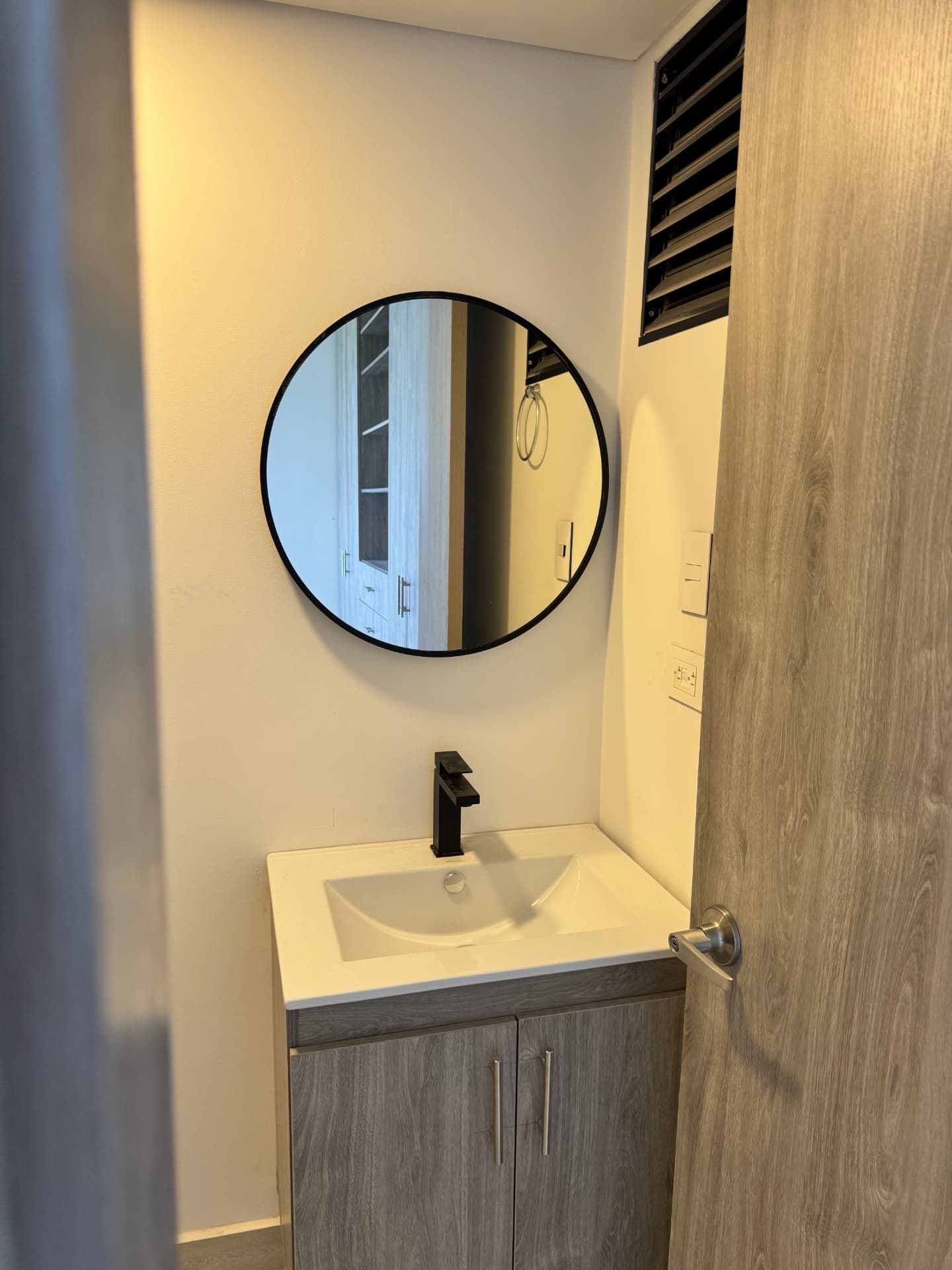 Baño con mueble flotante y espejo circular